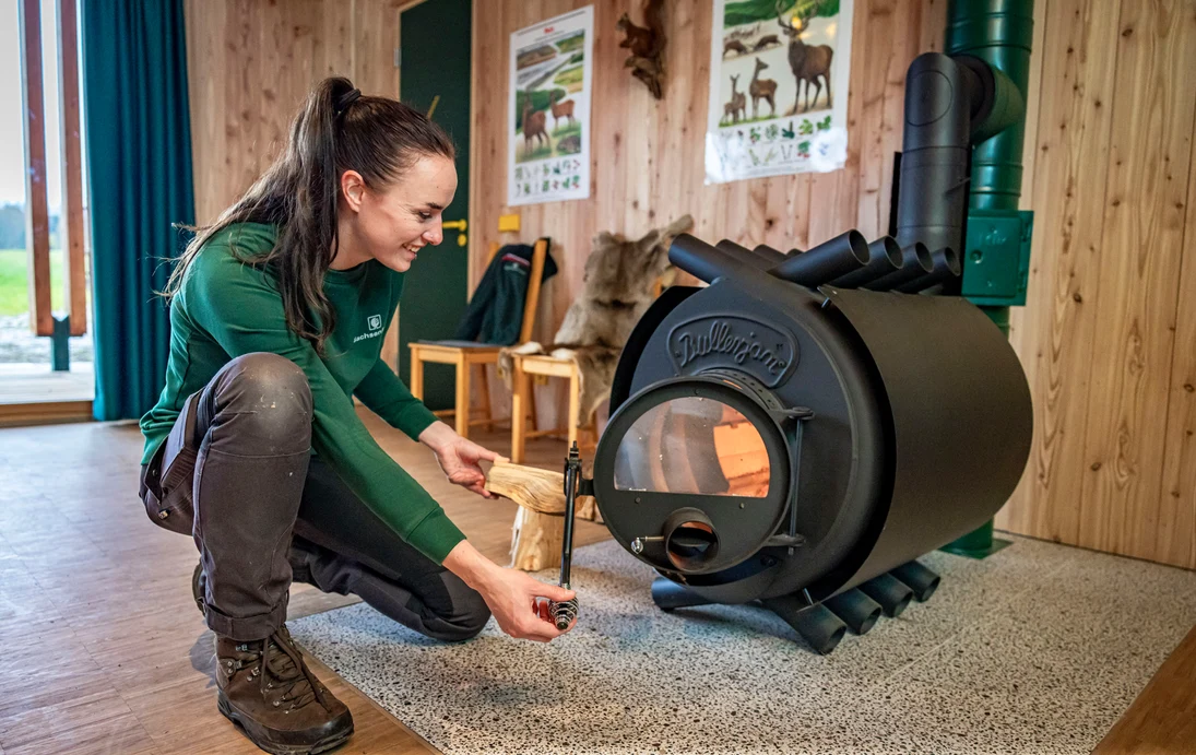 Frau Ahnert beim Feuermachen am Holzofen.
