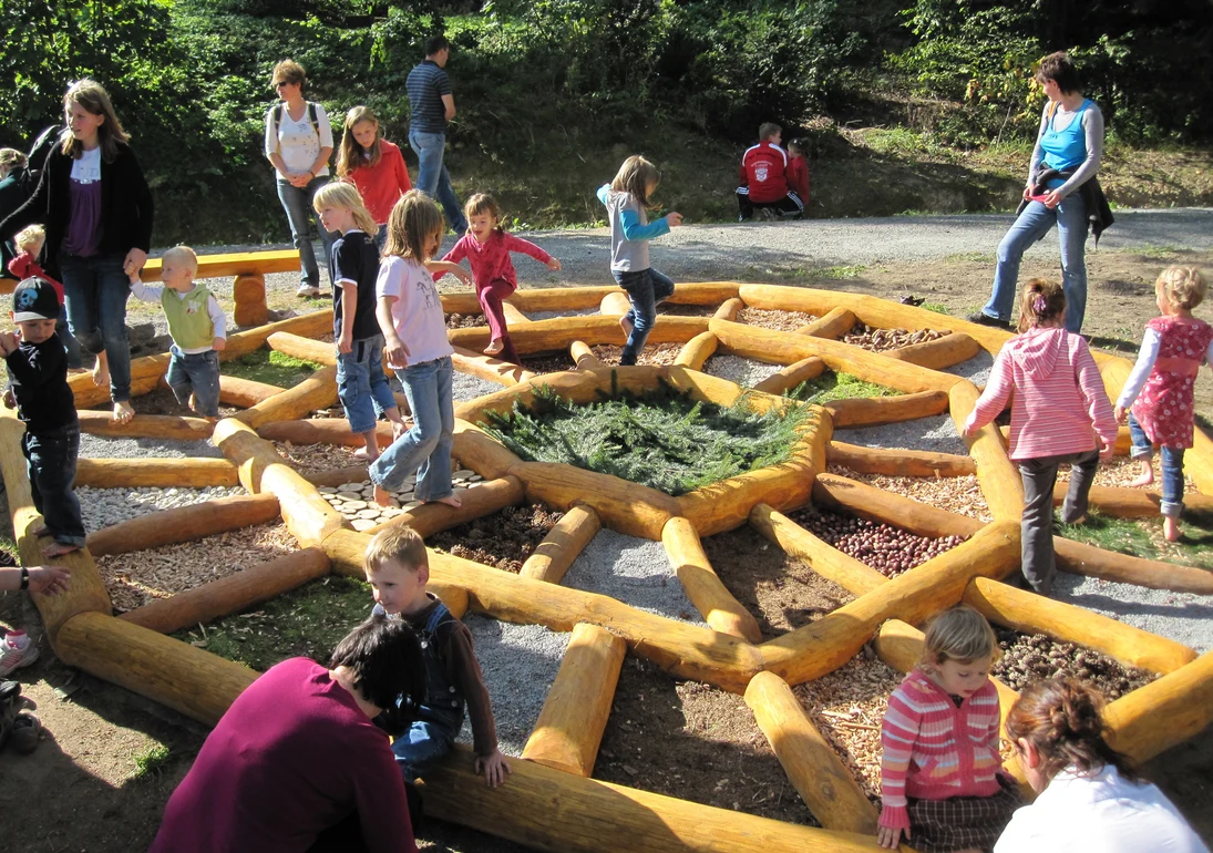 Kinder auf dem Barfußrad im Freigelände.