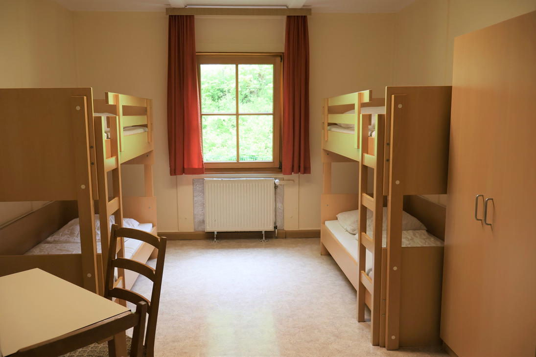 Ein typisches Schülerzimmer mit Hochbetten und weiteren Holzmöbeln.